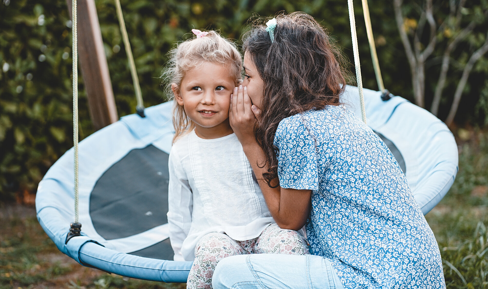 Kinder flüstern sich ins Ohr